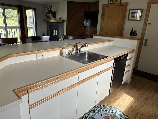 kitchen with dishwasher, white cabinetry, sink, and light hardwood / wood-style flooring