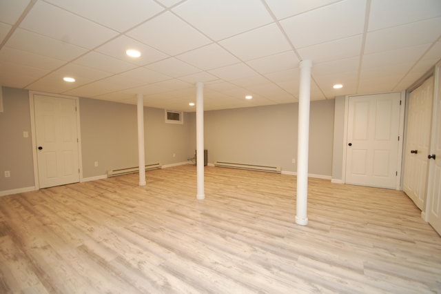 basement featuring light wood-type flooring and baseboard heating