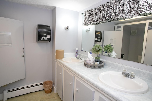 bathroom featuring tile patterned floors, vanity, toilet, and a baseboard heating unit