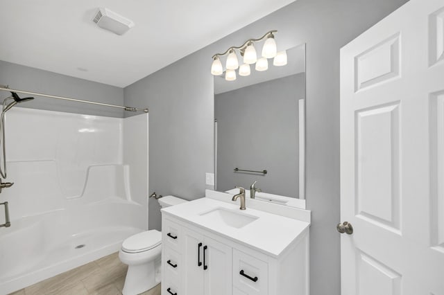 bathroom with toilet, vanity, and a shower