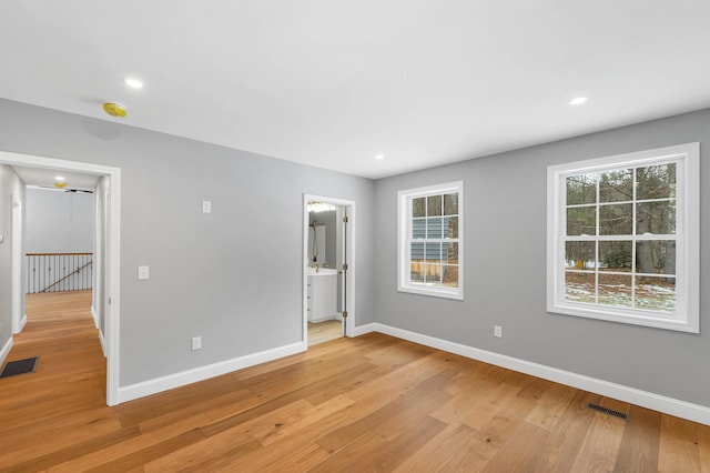 unfurnished bedroom featuring light hardwood / wood-style floors and connected bathroom