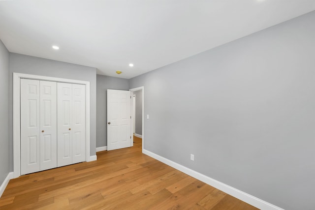 unfurnished bedroom featuring light hardwood / wood-style flooring and a closet