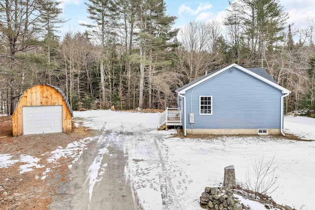 view of snow covered exterior featuring an outdoor structure and a garage