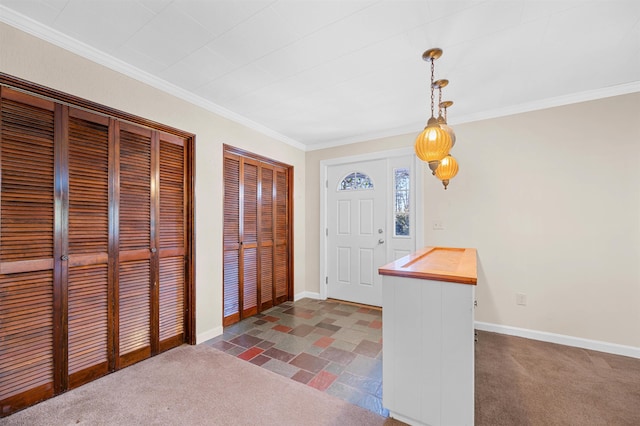 carpeted foyer featuring ornamental molding