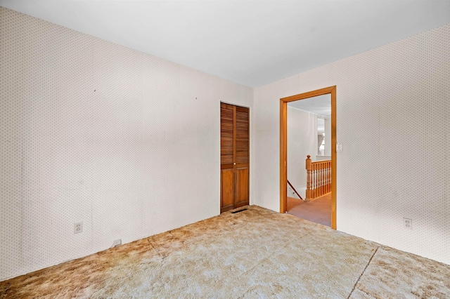 unfurnished room featuring light carpet