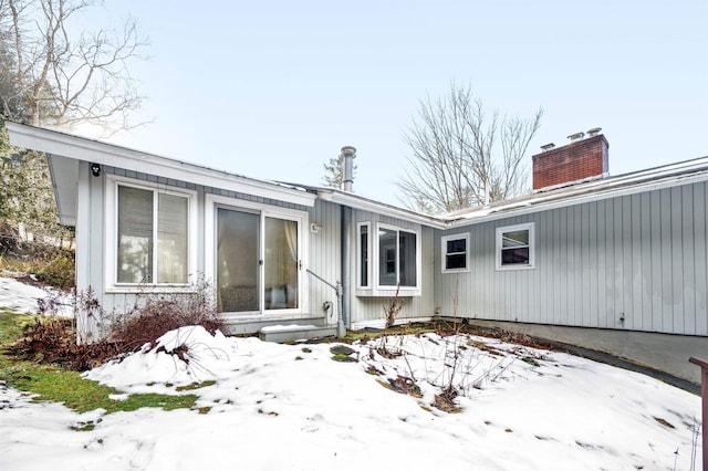 view of snow covered rear of property