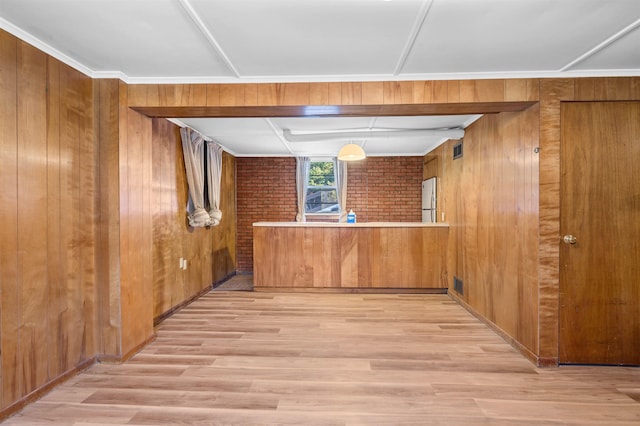 interior space with wooden walls, light hardwood / wood-style flooring, white fridge, and brick wall