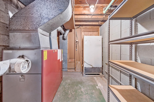 basement with heating unit and white refrigerator