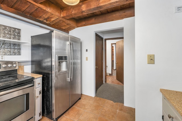 kitchen featuring wooden ceiling, light tile patterned floors, appliances with stainless steel finishes, beam ceiling, and white cabinetry