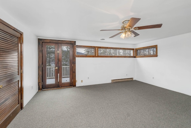 carpeted spare room with a baseboard radiator and ceiling fan