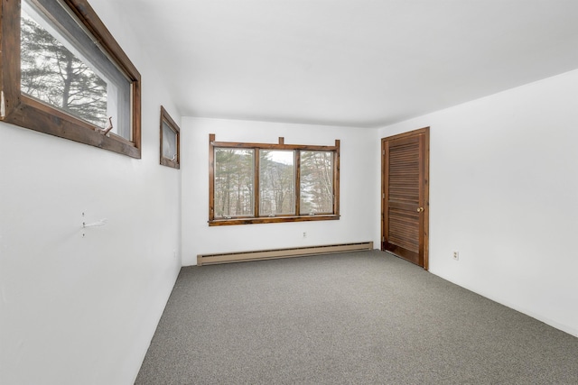 carpeted spare room featuring a baseboard heating unit