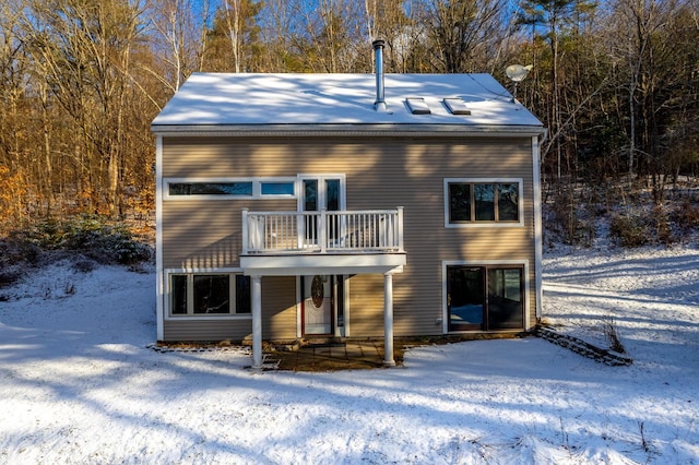 snow covered property with a balcony