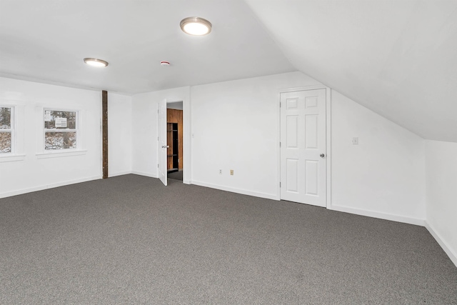 bonus room featuring dark colored carpet and vaulted ceiling