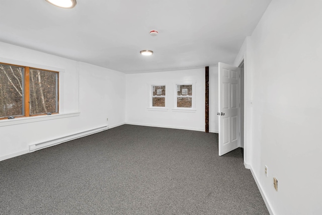 carpeted empty room with a baseboard heating unit