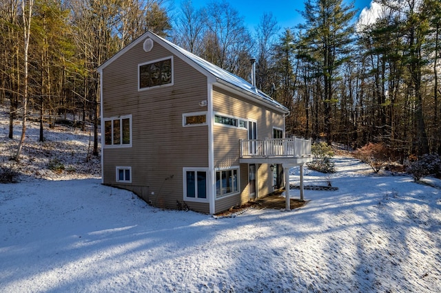 view of snowy exterior with a wooden deck