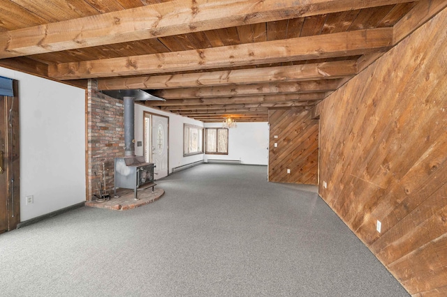 basement with wooden ceiling, a wood stove, and wooden walls