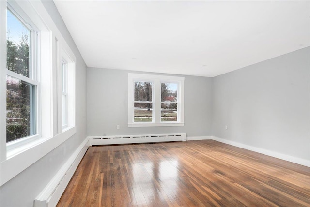 spare room featuring hardwood / wood-style flooring and baseboard heating