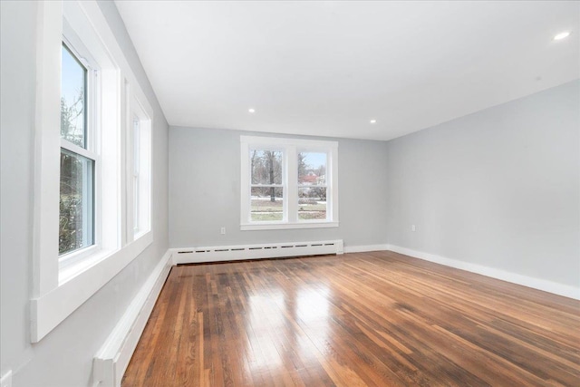 spare room featuring hardwood / wood-style floors and a baseboard heating unit