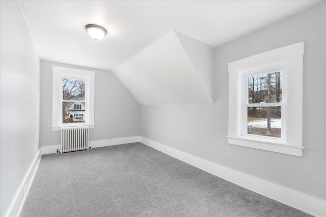 bonus room with carpet flooring, a wealth of natural light, radiator heating unit, and lofted ceiling