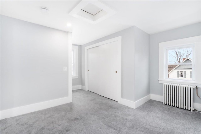 additional living space featuring light colored carpet and radiator heating unit