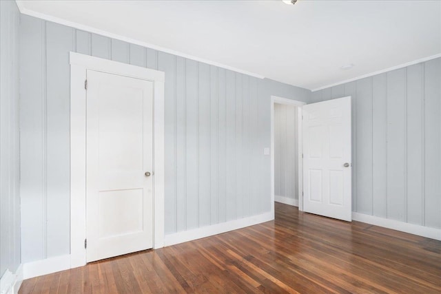 spare room featuring crown molding and dark wood-type flooring