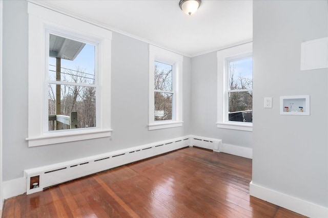 interior space featuring dark hardwood / wood-style flooring, ornamental molding, and a baseboard heating unit