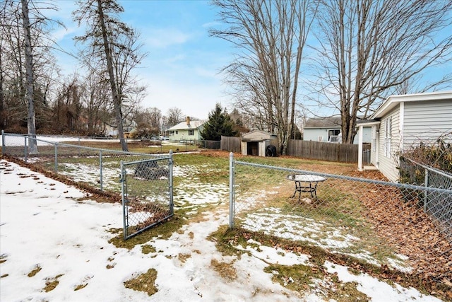 yard covered in snow featuring a storage unit