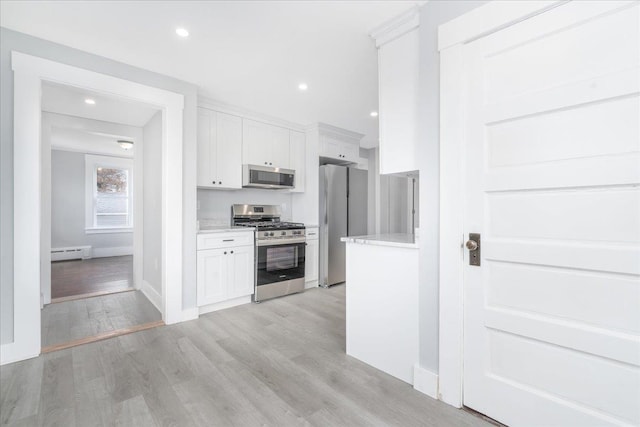 kitchen with baseboard heating, white cabinets, light wood-type flooring, and appliances with stainless steel finishes