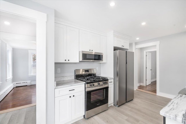 kitchen featuring a baseboard heating unit, light wood-type flooring, appliances with stainless steel finishes, light stone counters, and white cabinetry