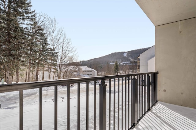 snow covered back of property with a mountain view