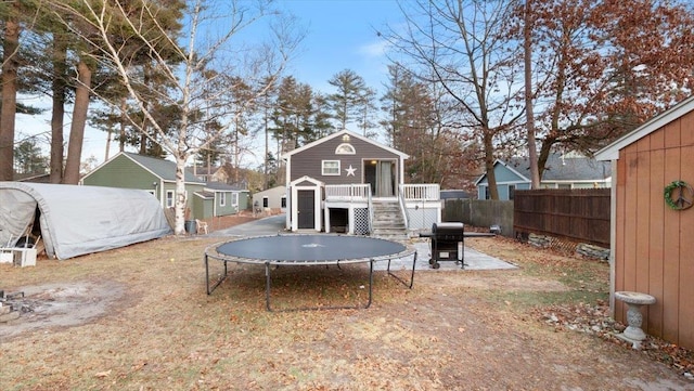 view of yard featuring a storage unit, a deck, and a trampoline