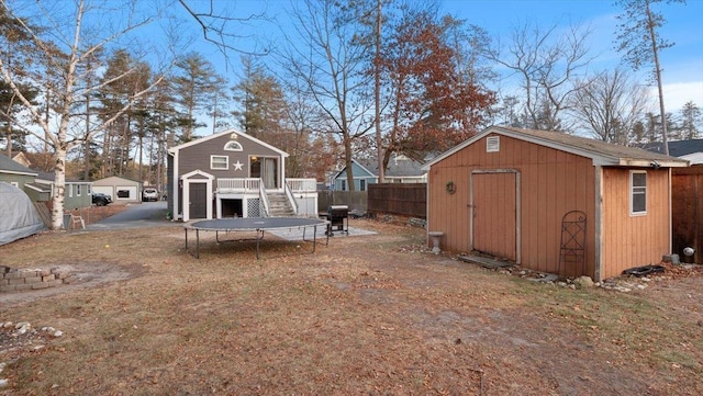 view of yard featuring a shed, a trampoline, and a deck