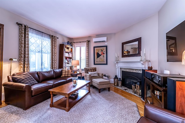 living room featuring an AC wall unit, a premium fireplace, and hardwood / wood-style flooring