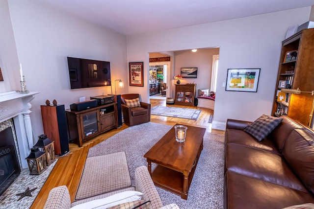 living room featuring a high end fireplace and light hardwood / wood-style floors