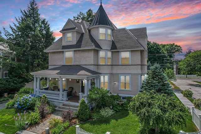 victorian house featuring covered porch and a yard