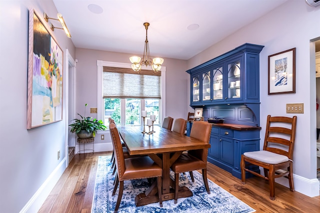 dining area featuring hardwood / wood-style flooring and an inviting chandelier