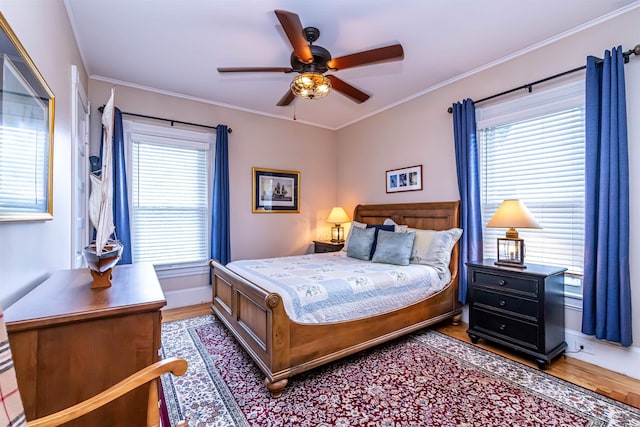 bedroom featuring ceiling fan, hardwood / wood-style floors, and crown molding