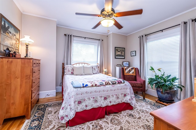 bedroom featuring light hardwood / wood-style flooring, ceiling fan, and crown molding