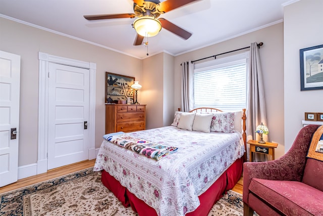 bedroom featuring ceiling fan, crown molding, and wood-type flooring