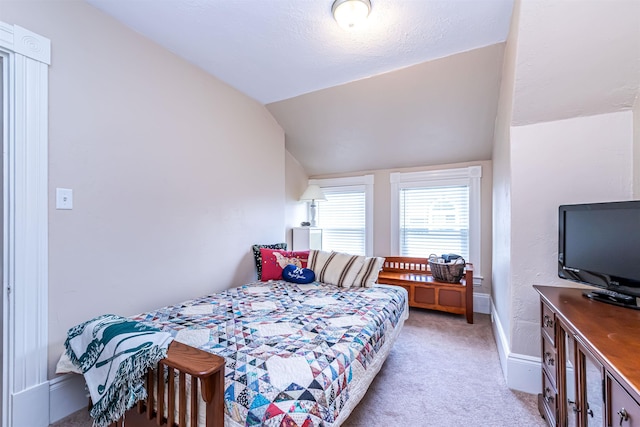 bedroom with lofted ceiling and light carpet