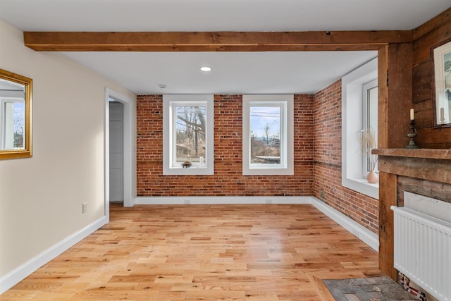 interior space featuring brick wall, light wood-type flooring, and radiator