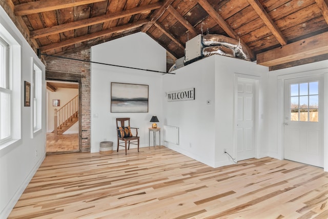 unfurnished living room featuring beamed ceiling, light wood-type flooring, and wood ceiling