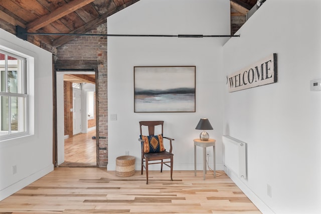 sitting room featuring lofted ceiling with beams, a healthy amount of sunlight, light wood-type flooring, and wood ceiling