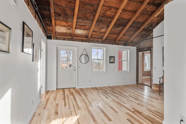 foyer entrance featuring wood ceiling, lofted ceiling with beams, and light wood-type flooring