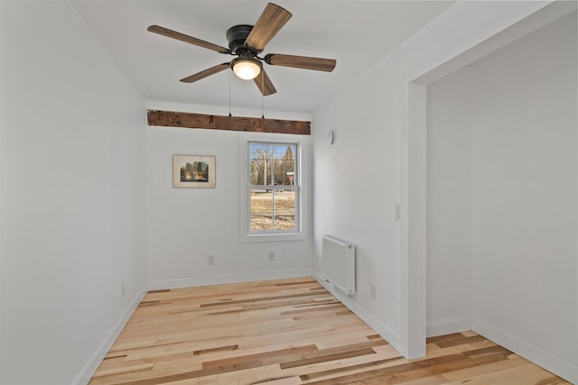 unfurnished room featuring light hardwood / wood-style floors, radiator, and ceiling fan