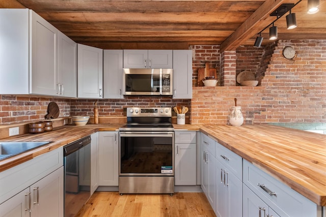 kitchen featuring stainless steel appliances, light hardwood / wood-style floors, butcher block counters, and wood ceiling