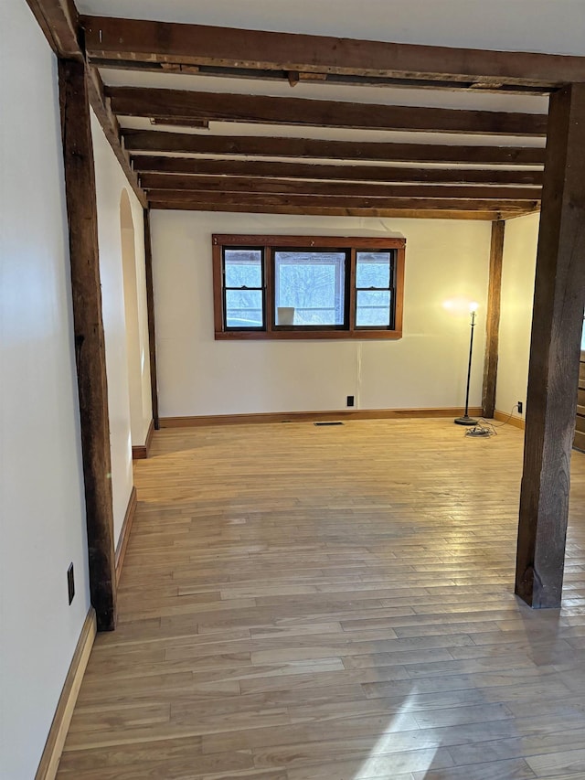 empty room featuring hardwood / wood-style flooring and beam ceiling