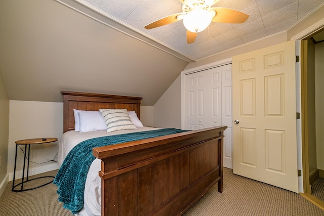 carpeted bedroom featuring a closet, vaulted ceiling, and ceiling fan