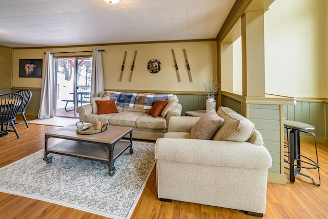 living room with crown molding and light hardwood / wood-style floors