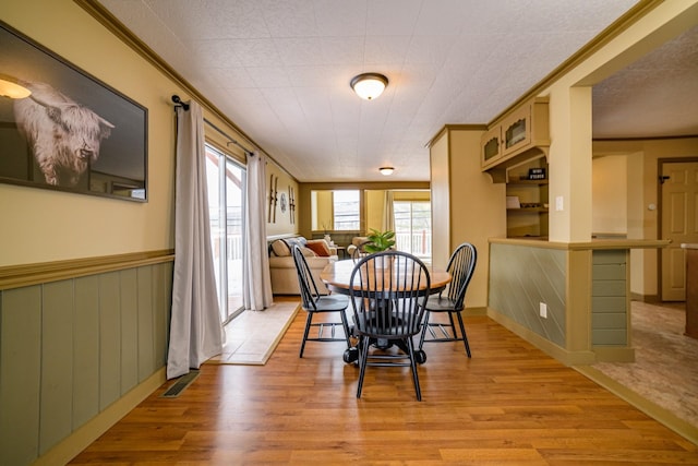 dining room featuring light hardwood / wood-style flooring and crown molding